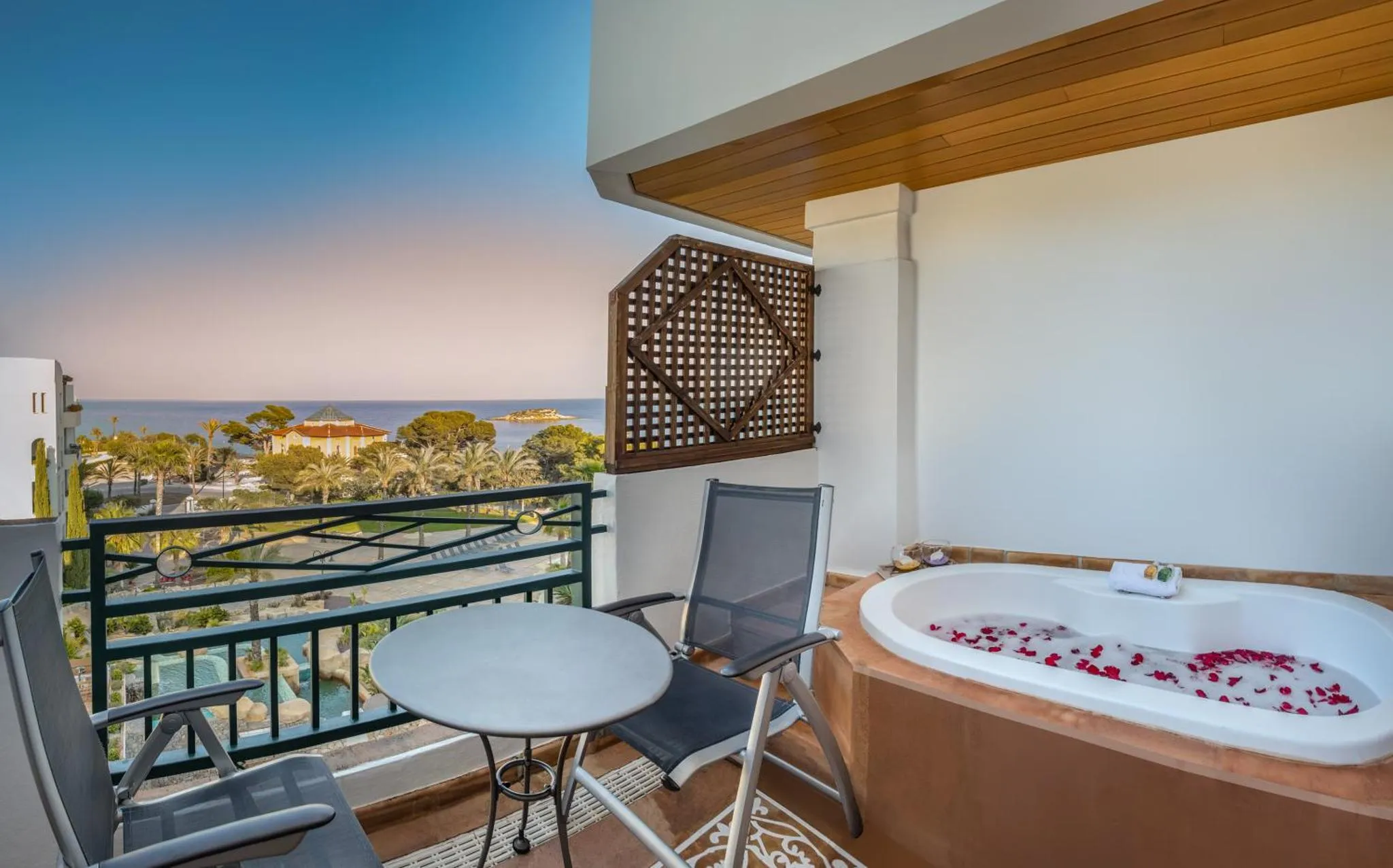 Terrasse avec jacuzzi et vue sur la mer au crépuscule.