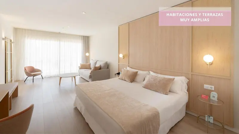 Une chambre lumineuse avec un grand lit et un coin salon.