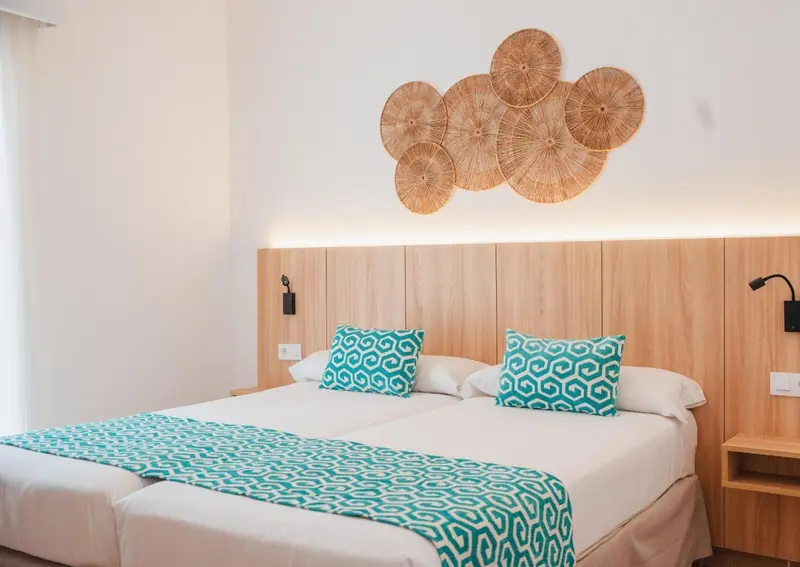 Une chambre lumineuse avec un grand lit et une décoration murale en bois.