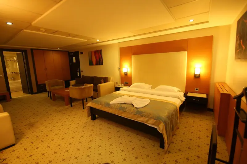 Une chambre lumineuse avec un grand lit et un coin salon.
