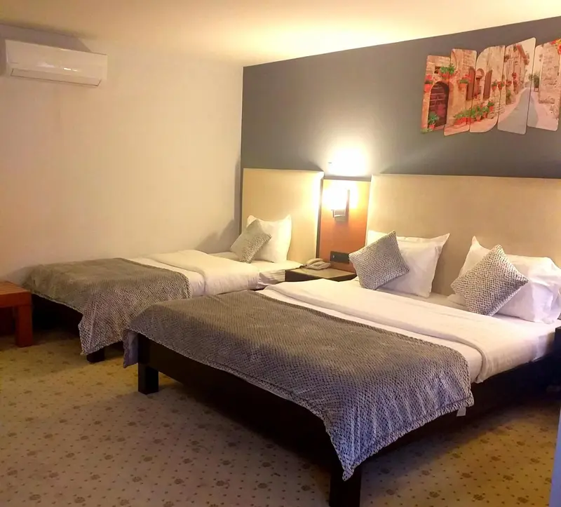 Chambre avec deux lits simples et une décoration murale.