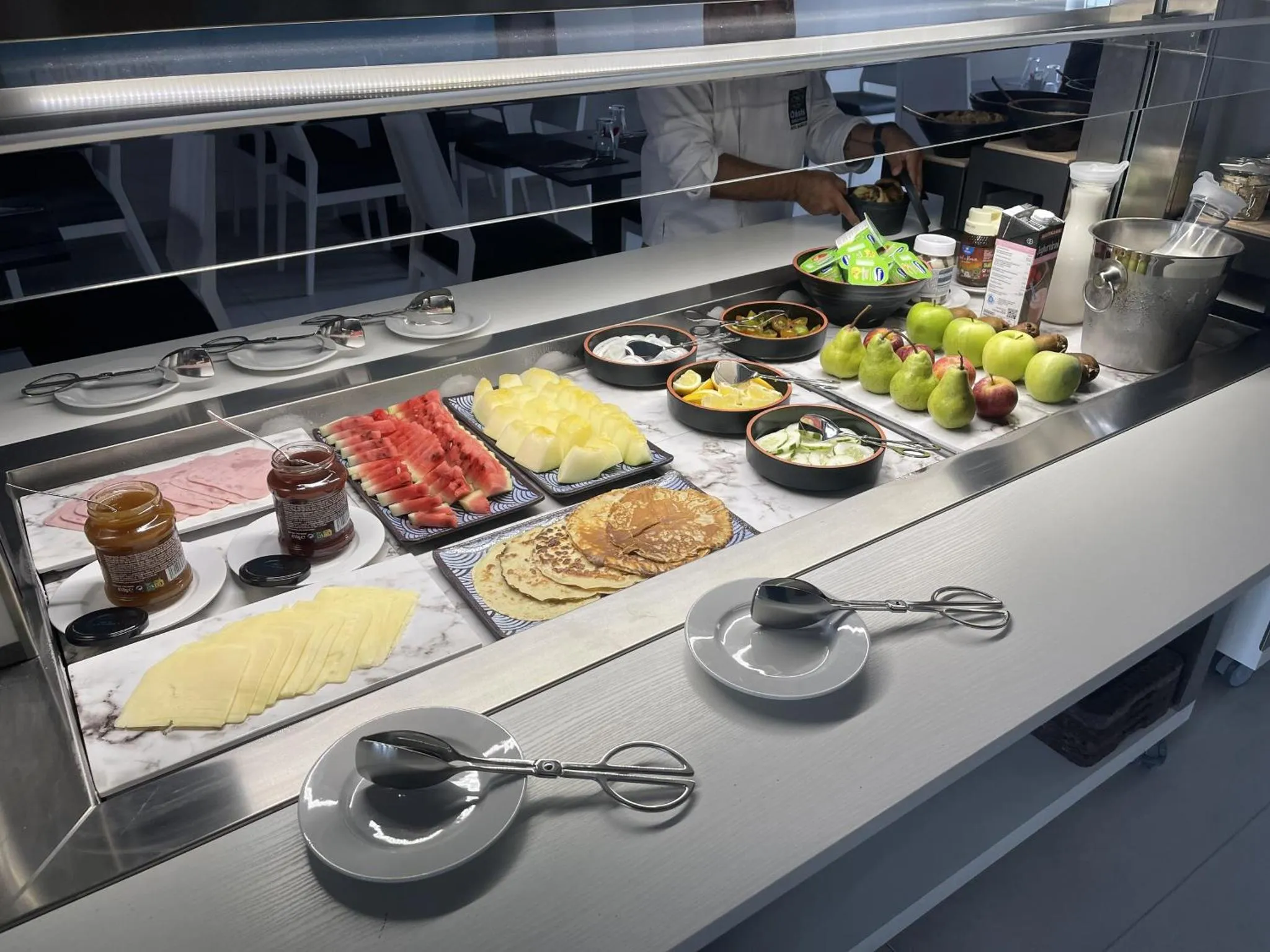 Un buffet propose une variété de plats et de fruits frais.