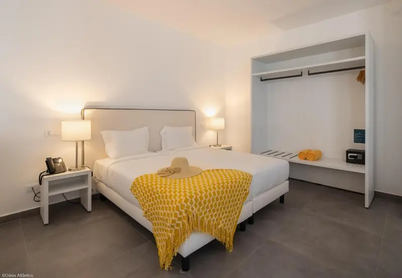 Une chambre lumineuse avec un grand lit et un espace de rangement.