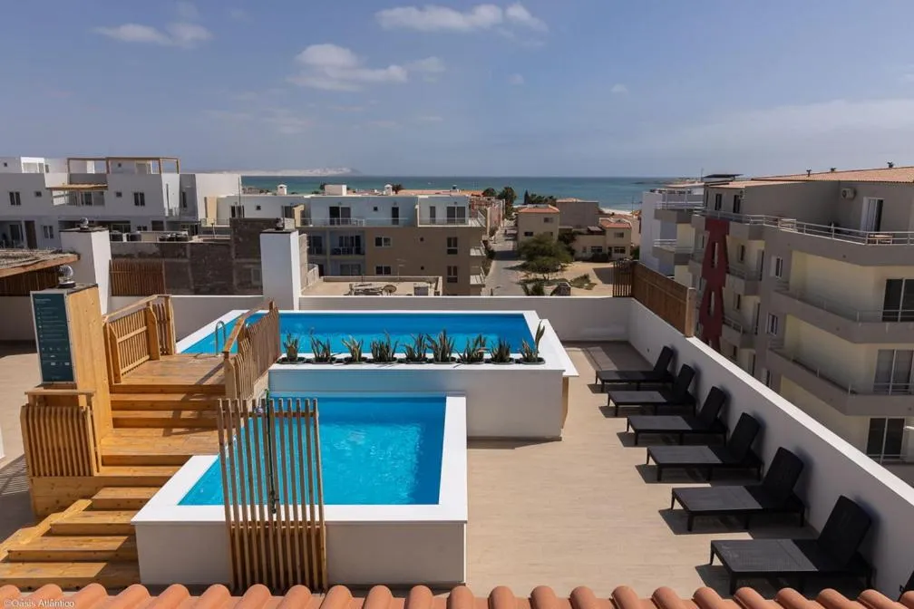 Terrasse avec piscine et chaises longues.