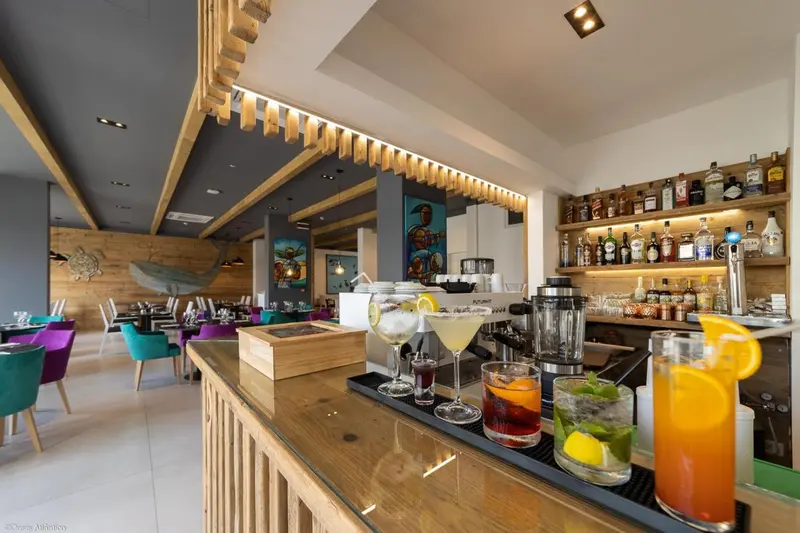 Un comptoir de bar en bois présente des cocktails colorés et des boissons.