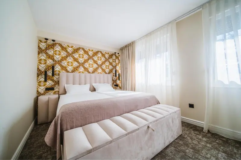 Une chambre lumineuse avec un grand lit et un mur décoratif.