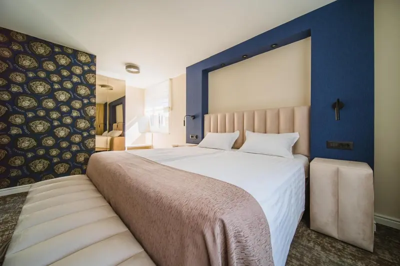 Une chambre à coucher lumineuse avec un grand lit recouvert d'une courtepointe.