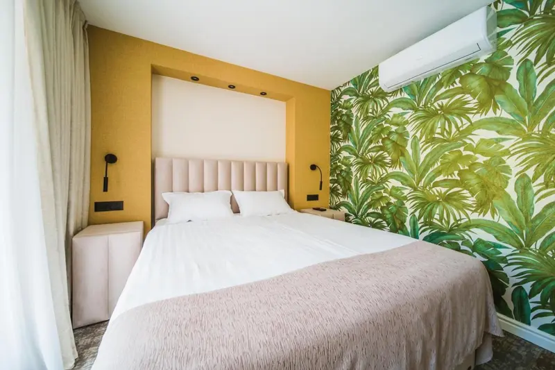Une chambre à coucher lumineuse avec un lit recouvert d'une couverture.