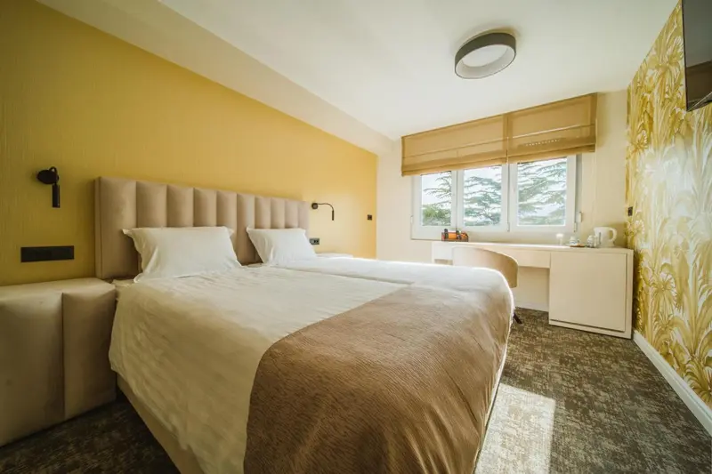 Une chambre lumineuse avec un grand lit et un bureau.