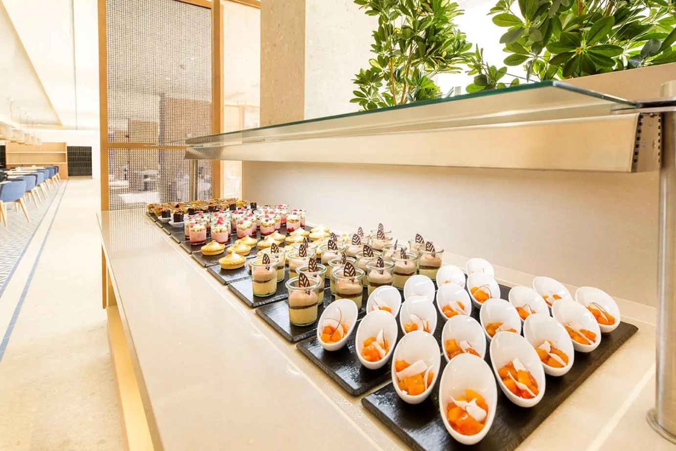 Un buffet propose une variété de desserts individuels et de verrines colorées.