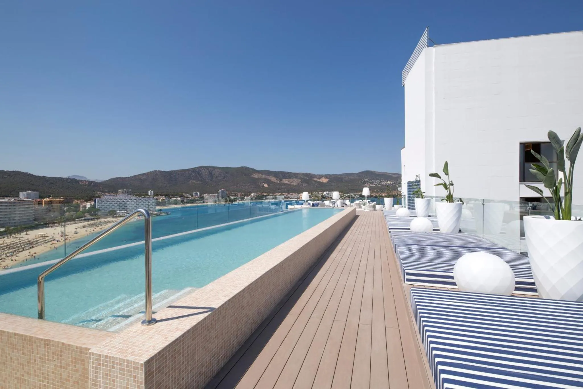 Terrasse avec piscine à débordement et vue sur la mer.