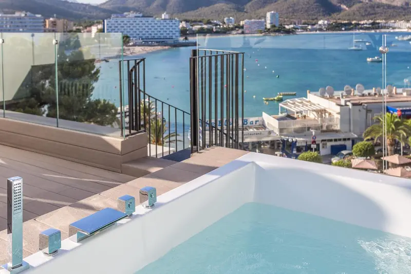 Jacuzzi sur une terrasse avec vue sur la mer et les montagnes.
