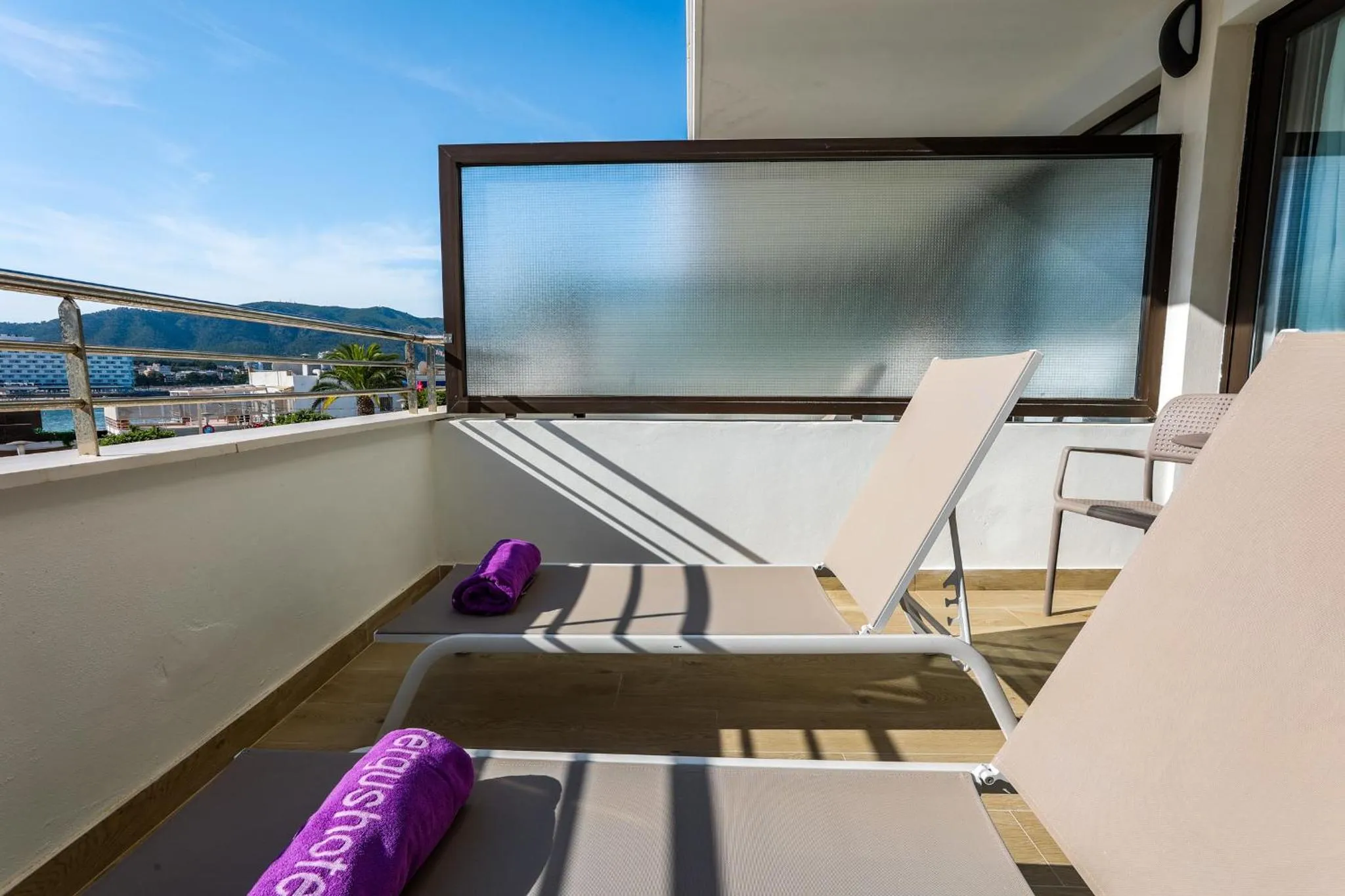 Terrasse avec deux transats et une vue sur la mer.