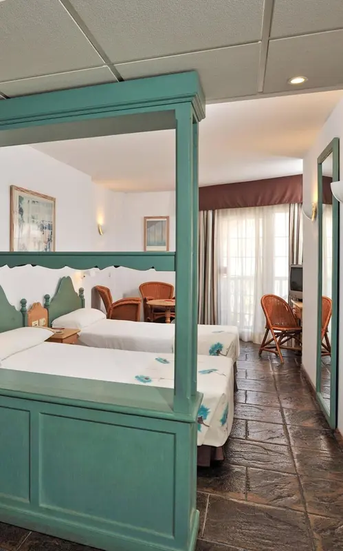 Une chambre avec deux lits simples et un coin repas.