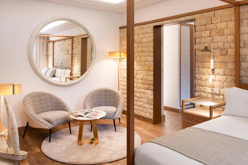 Espace de détente avec fauteuils et table basse dans une chambre décorée de pierre.
