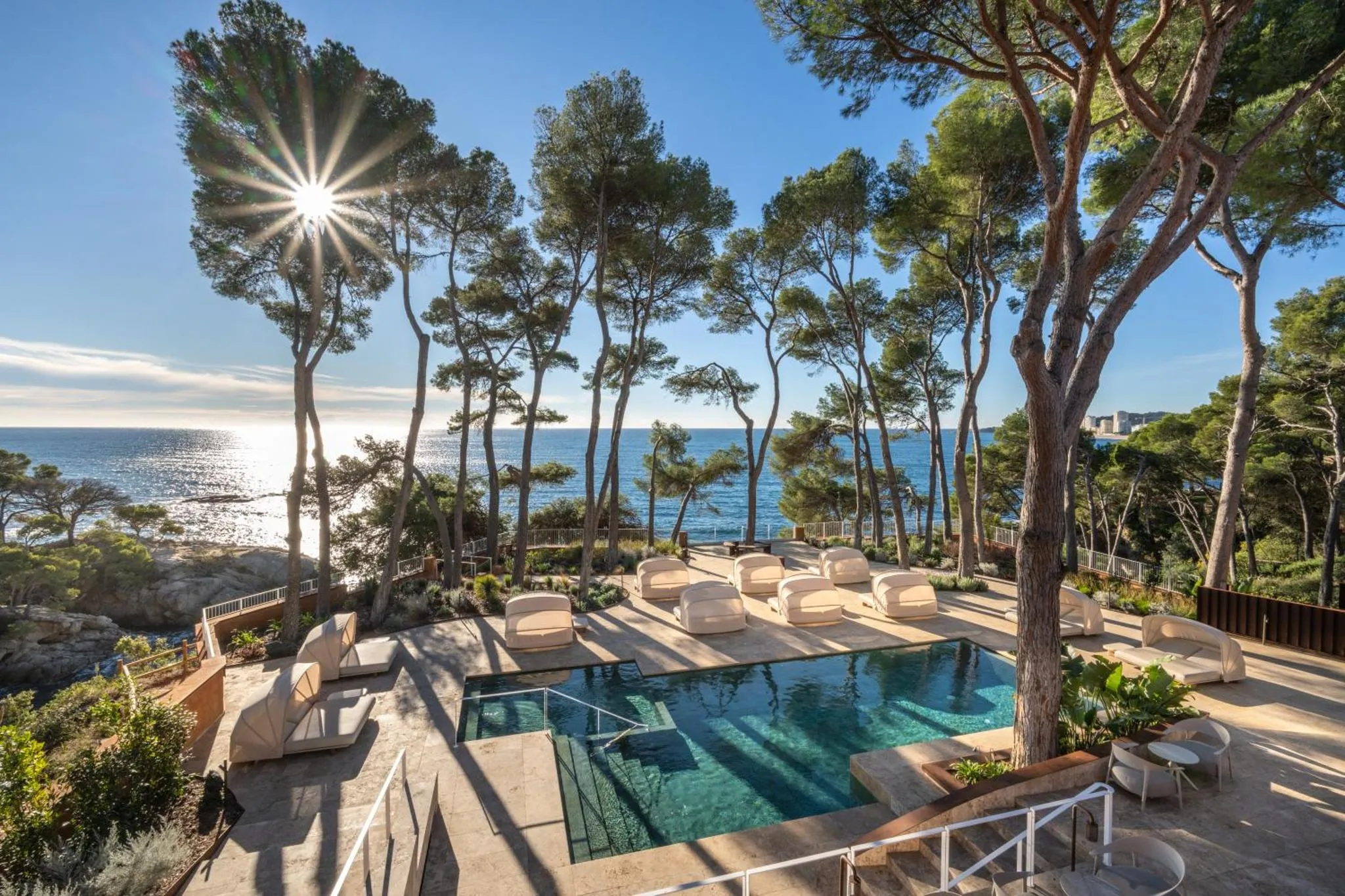 Terrasse avec piscine et vue sur la mer ensoleillée.
