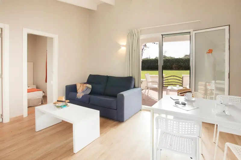 Un salon lumineux s'ouvre sur une terrasse avec vue sur un jardin.