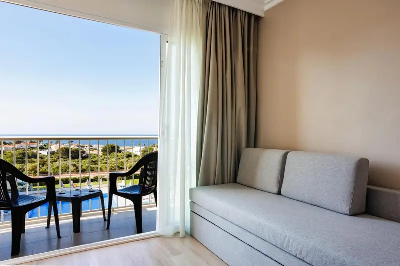 Vue sur la mer depuis un espace de détente avec canapé et mobilier d'extérieur.