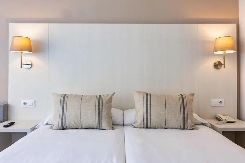 Une chambre avec un grand lit et des oreillers décoratifs.