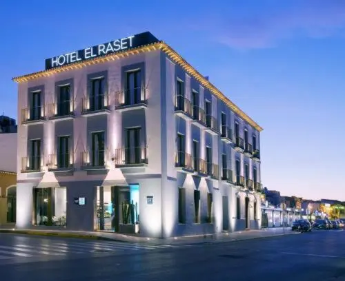 Façade d'un bâtiment à plusieurs étages éclairée la nuit.