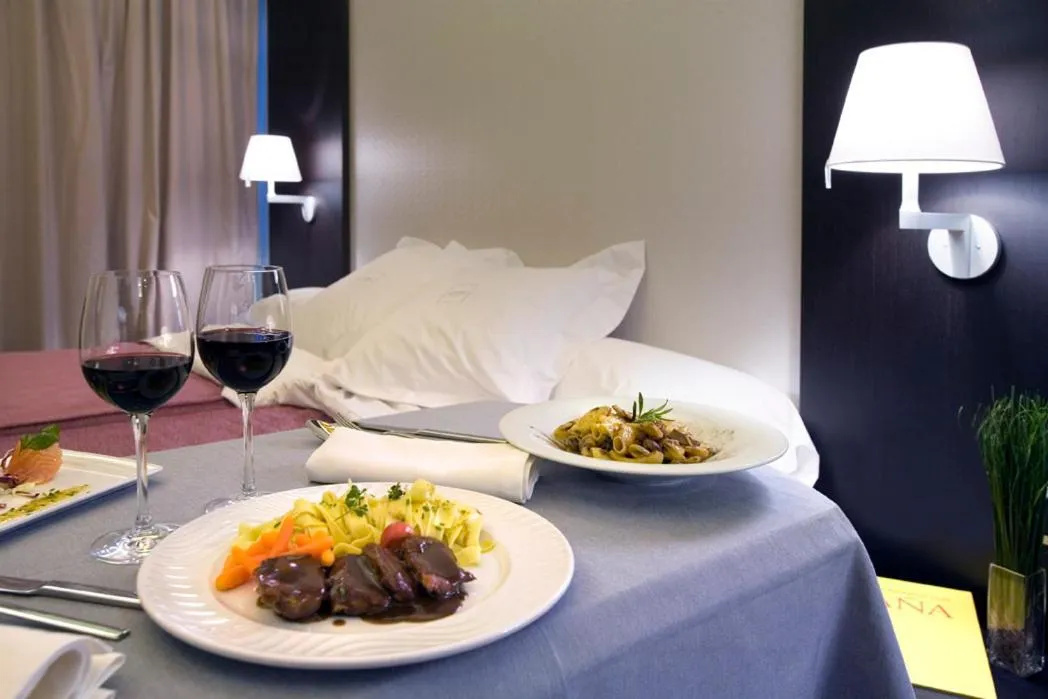 Une table est dressée avec des plats et des verres de vin dans une chambre.