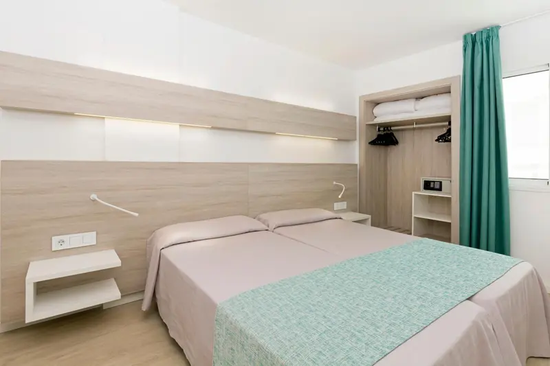 Une chambre lumineuse avec un grand lit et des rangements intégrés.