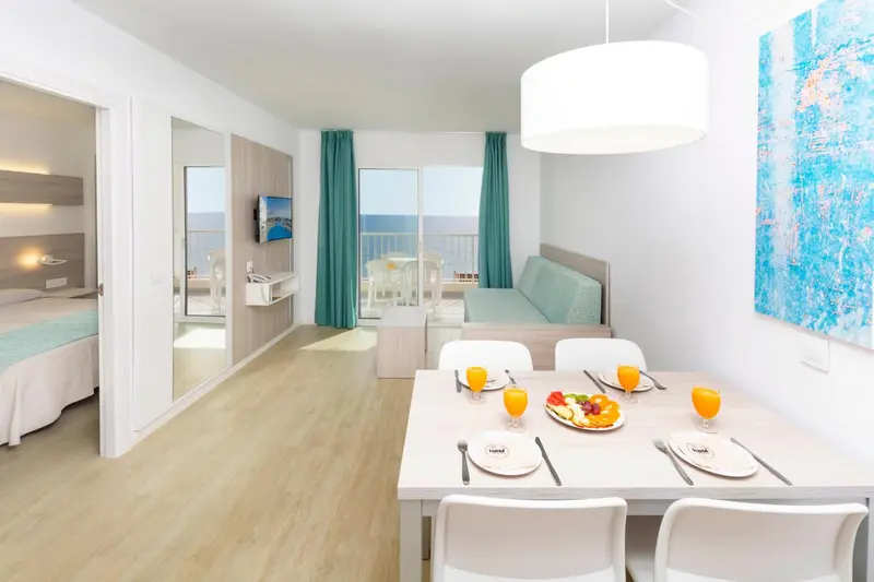 Une pièce lumineuse avec un coin repas et un espace détente.