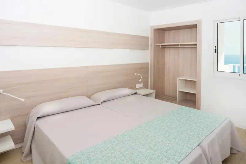 Une chambre lumineuse avec un grand lit et une vue sur la mer.