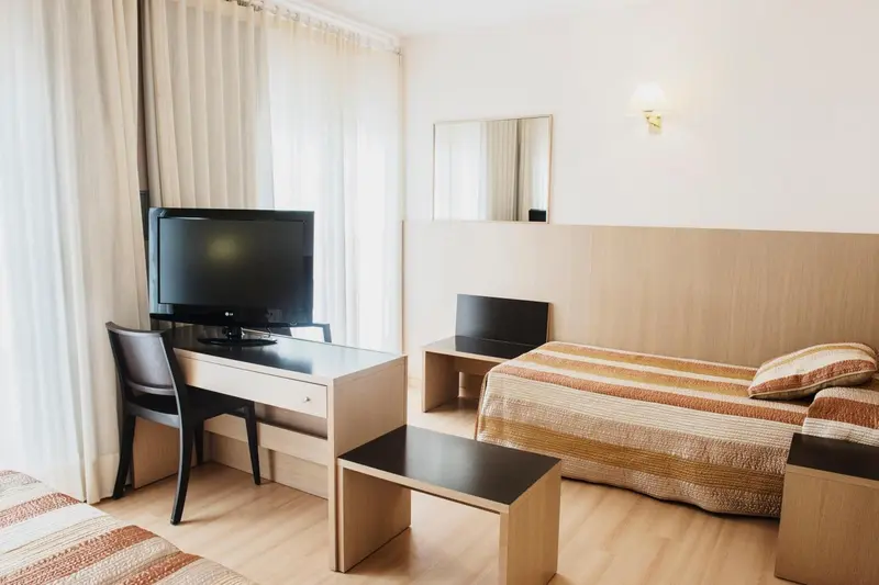 Une chambre lumineuse avec un bureau et un lit.
