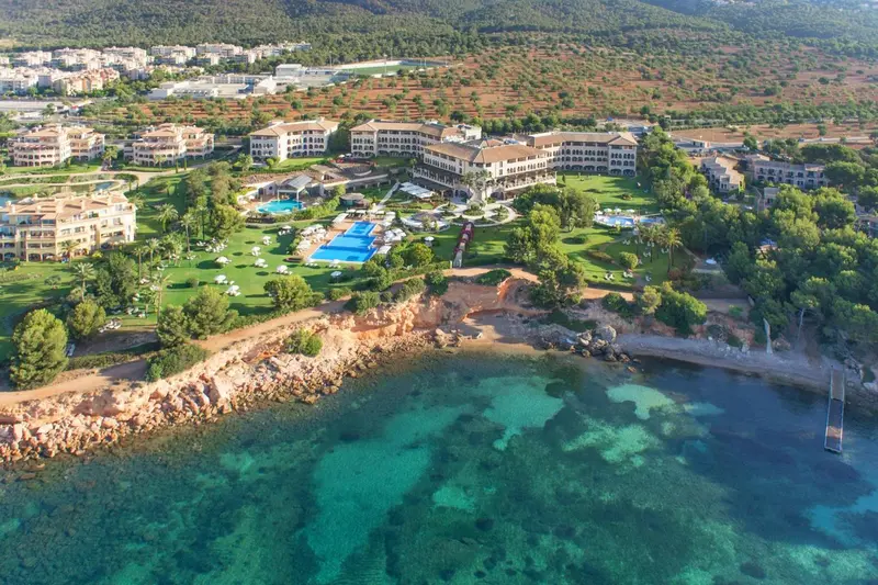 Vue aérienne d'un complexe hôtelier avec piscine et accès à la mer.