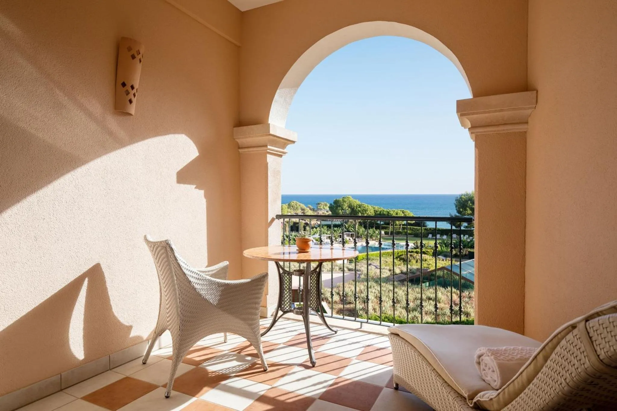 Terrasse avec mobilier d'extérieur donnant sur une vue mer et une piscine.