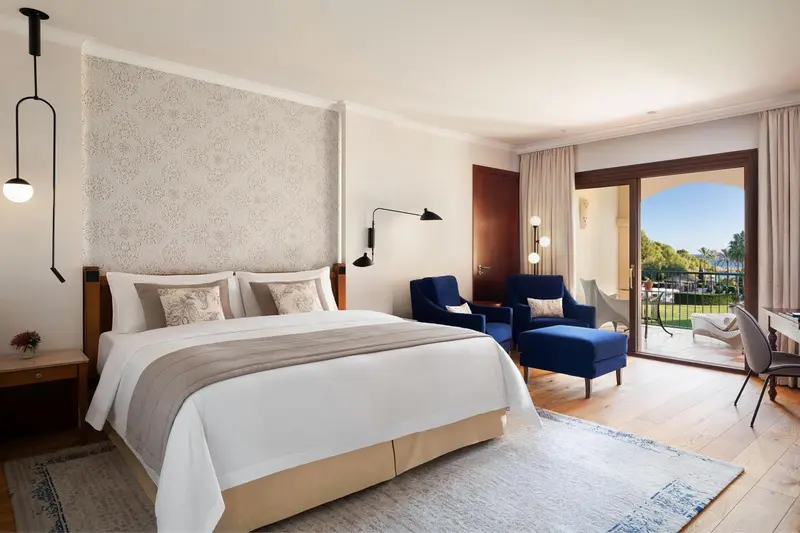 Une chambre lumineuse avec un grand lit et un coin salon.