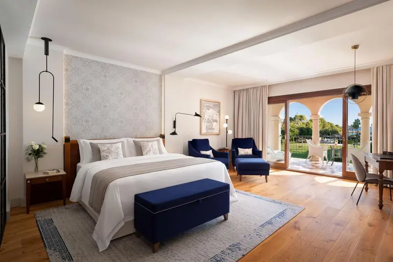 Une chambre lumineuse avec un grand lit et un coin salon.