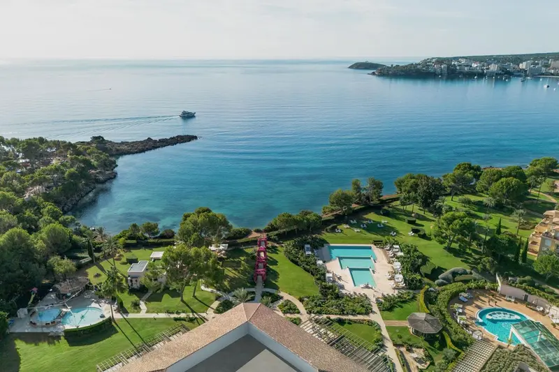 Vue aérienne d'une côte rocheuse avec des piscines et de la végétation luxuriante.