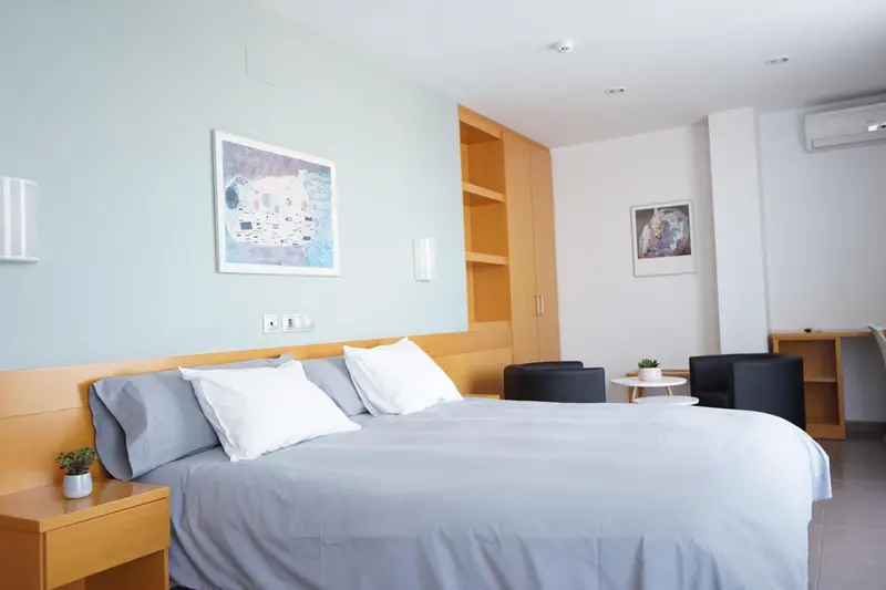 Une chambre lumineuse avec un grand lit et des meubles en bois.