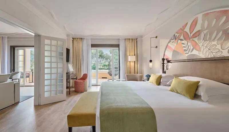 Une chambre lumineuse avec un lit double et un accès à une terrasse.