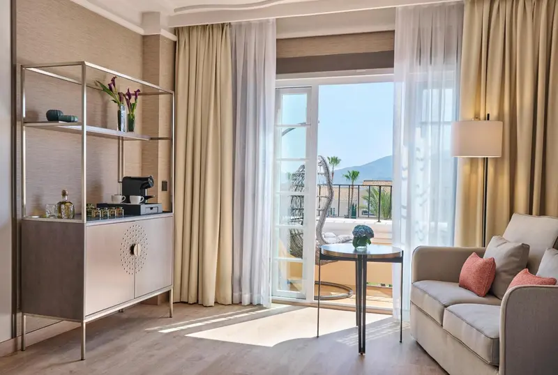Espace de séjour lumineux avec canapé et accès à un balcon.