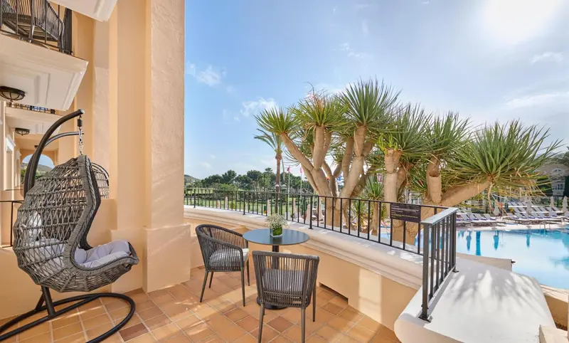 Terrasse avec mobilier d'extérieur et vue sur un jardin verdoyant.