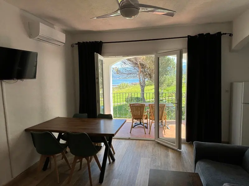 Une salle à manger lumineuse s'ouvre sur une terrasse avec vue sur la mer.