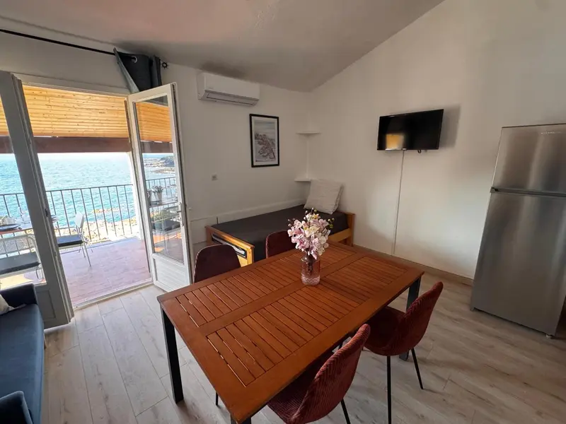 Une salle à manger lumineuse s'ouvre sur une terrasse avec vue sur la mer.