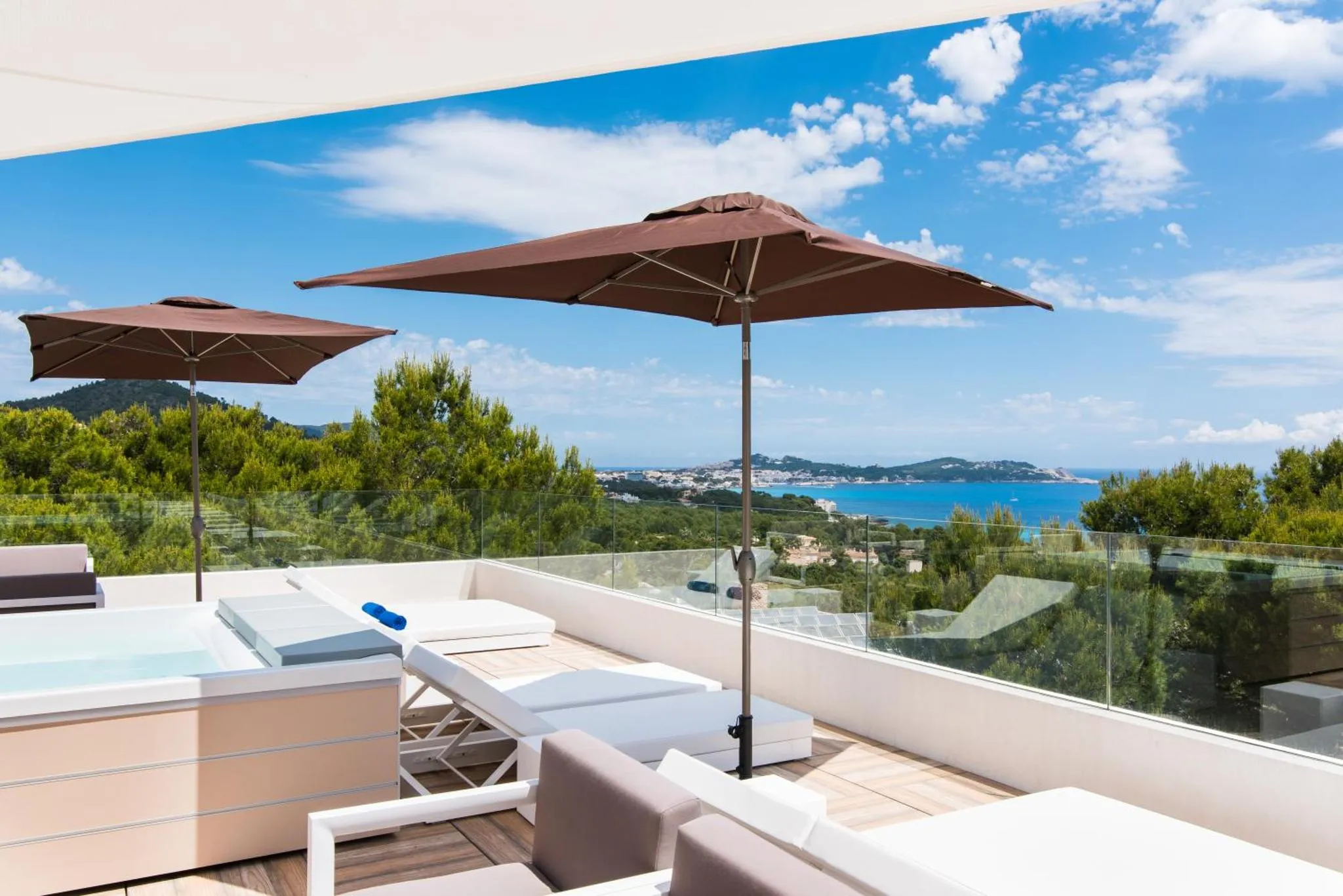 Terrasse aménagée avec transats et vue sur la mer.