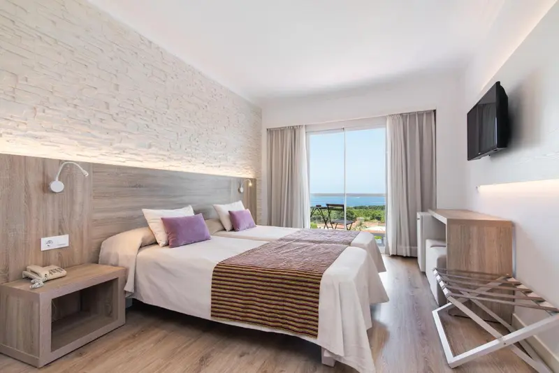 Une chambre lumineuse avec un grand lit et une vue sur la mer.