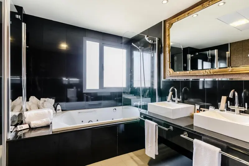 Une salle de bain moderne avec baignoire et deux vasques.