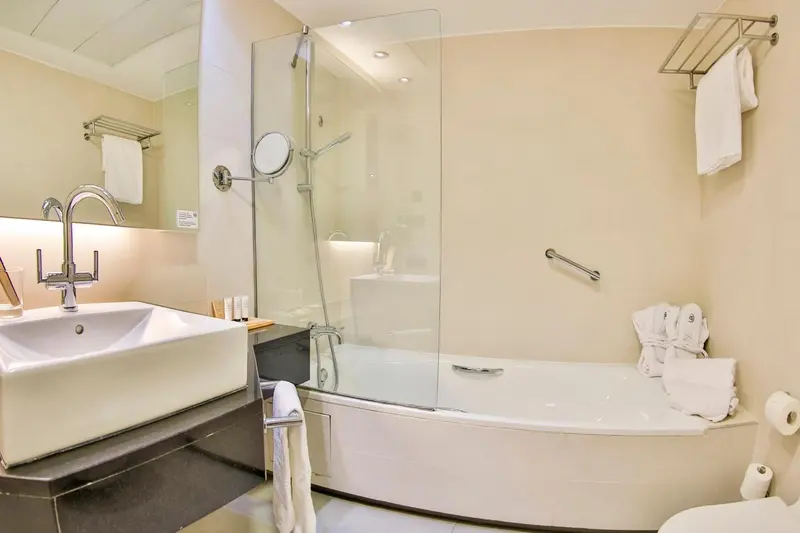 Une salle de bain lumineuse avec baignoire et douche à l'italienne.
