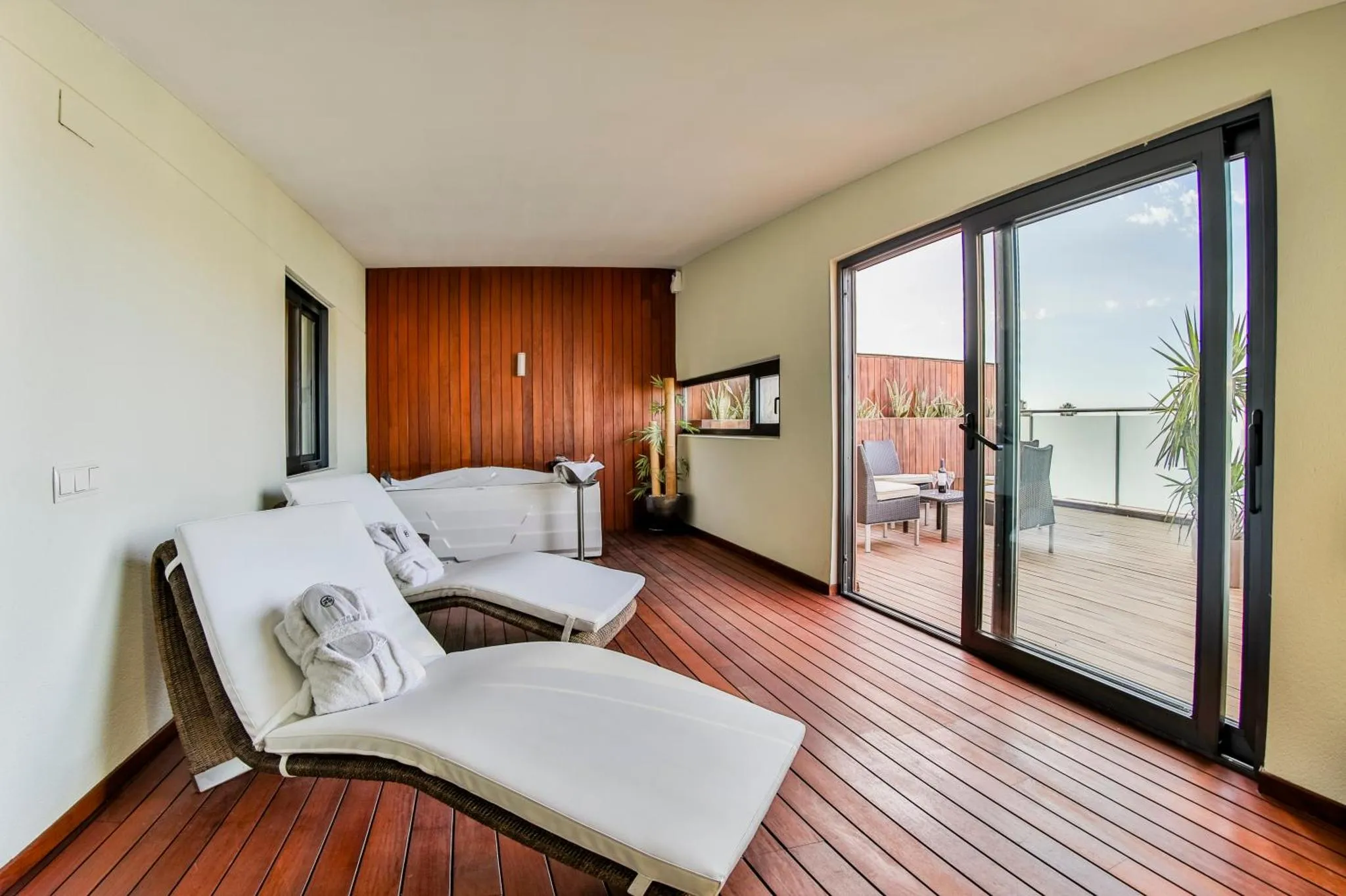 Espace de détente extérieur avec chaises longues et vue sur la mer.