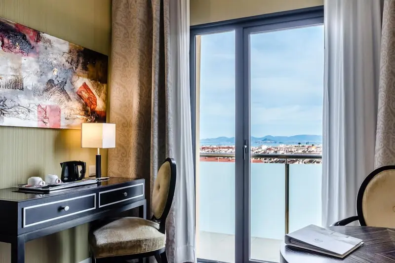 Une chambre lumineuse avec un bureau et une vue sur la mer.
