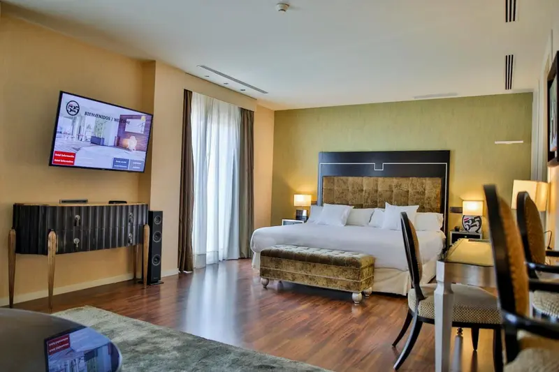 Une chambre spacieuse avec un grand lit et un coin repas.