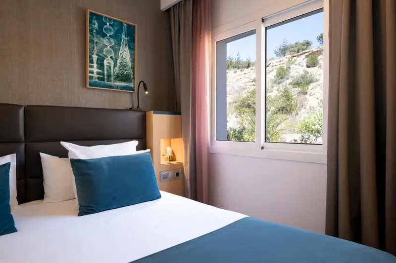 Une chambre avec un lit et une vue sur un paysage montagneux.