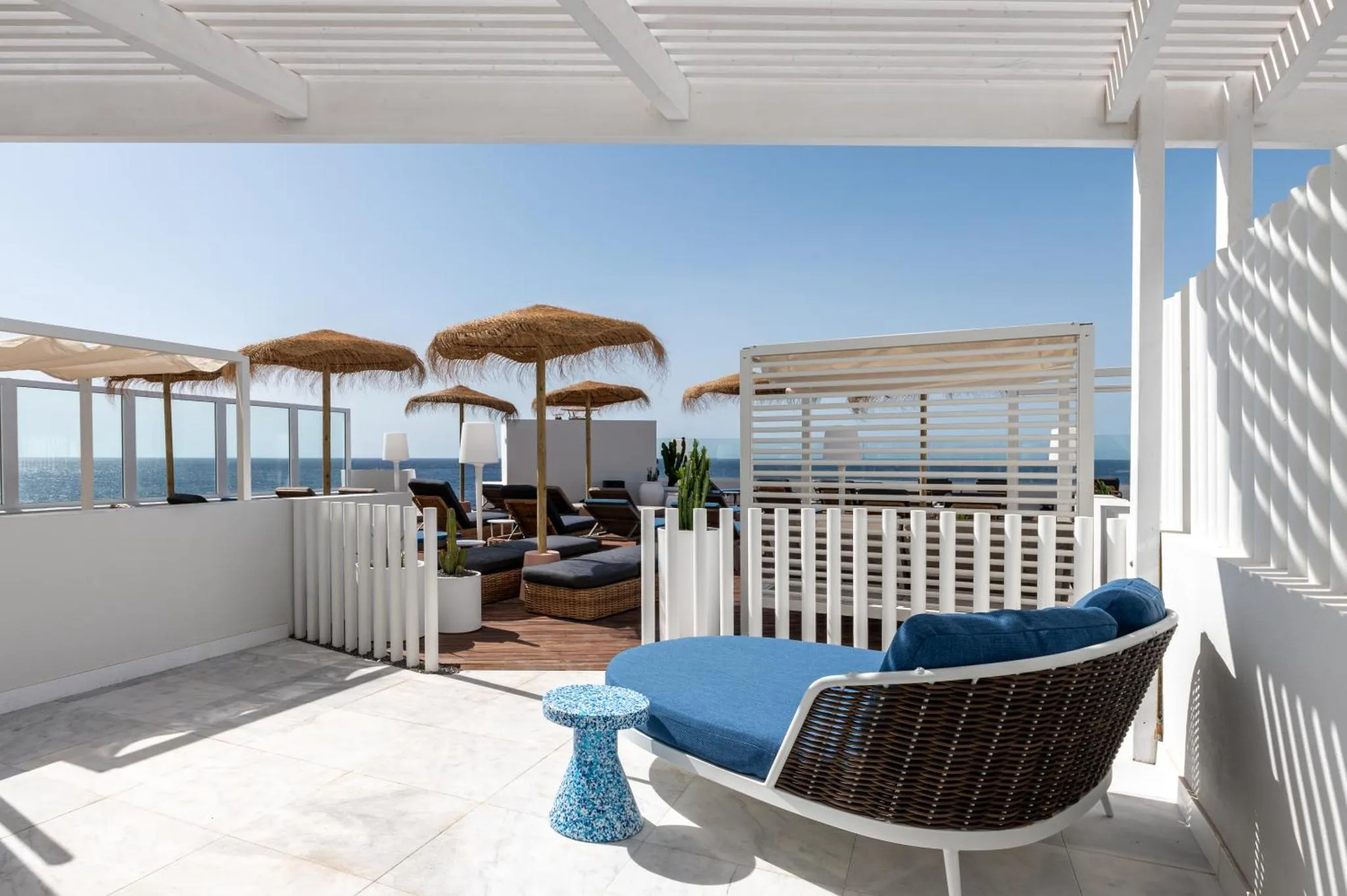 Terrasse aménagée avec mobilier de détente et vue sur la mer.