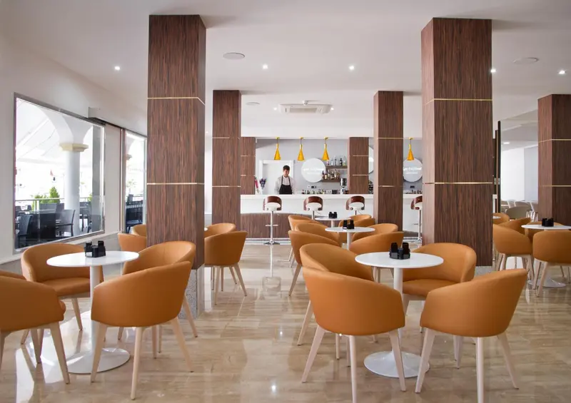 Un espace de détente avec des fauteuils et des tables basses près d'un bar.